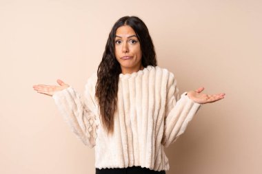 El kaldırırken şüpheleri olan izole arka plan üzerinde genç kadın