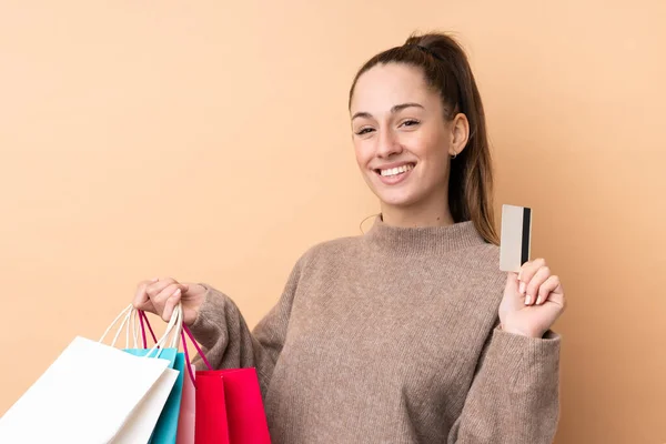 Jonge Brunette Vrouw Geïsoleerde Achtergrond Holding Boodschappentassen Een Creditcard — Stockfoto