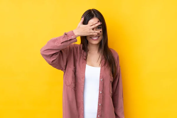 Young Brunette Woman Isolated Yellow Background Covering Eyes Hands Smiling — Stockfoto