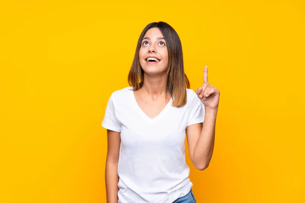 Jovem Mulher Sobre Fundo Amarelo Isolado Pensando Uma Ideia Apontando — Fotografia de Stock