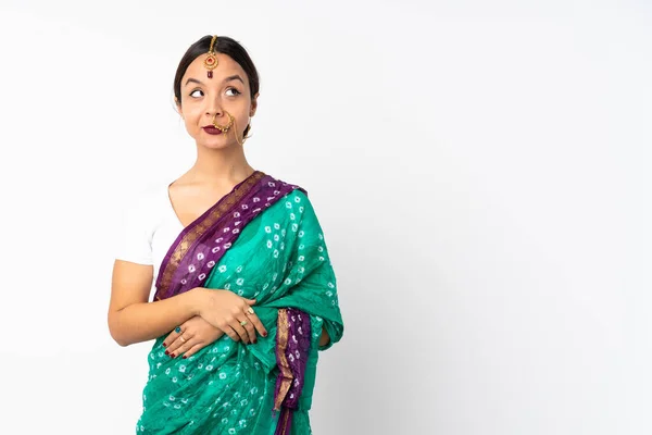 若いインド人の女性は 側を見ている間に疑問を持っている白い背景に隔離 — ストック写真