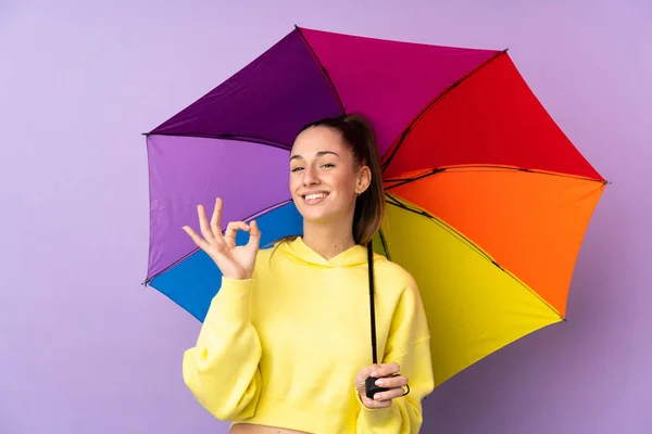 Jong Brunette Vrouw Holding Een Paraplu Geïsoleerde Paars Muur Tonen — Stockfoto