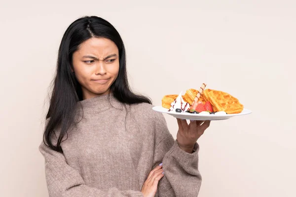 Teenager Asian Girl Holding Waffles Isolated Beige Background Sad Expression — Stock Photo, Image