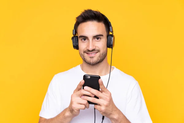 Jeune Homme Sur Fond Jaune Écoutant Musique Avec Front Mobile — Photo