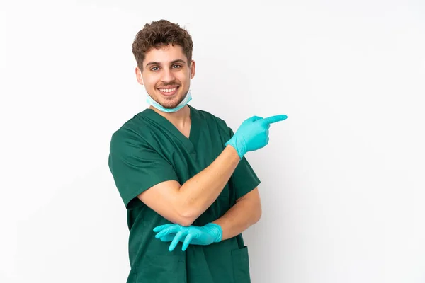 Cirurgião Uniforme Verde Isolado Fundo Branco Isolado Apontando Dedo Para — Fotografia de Stock