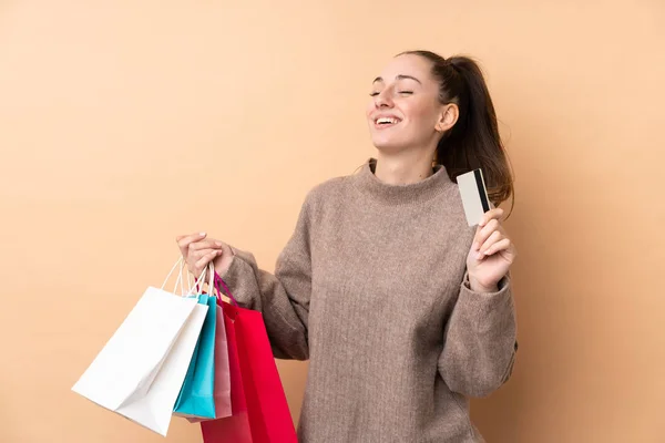 Joven Morena Sobre Fondo Aislado Sosteniendo Bolsas Compras Una Tarjeta —  Fotos de Stock