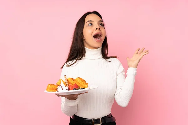 Young Brunette Woman Holding Waffles Isolated Pink Background Surprise Facial — Stock Photo, Image