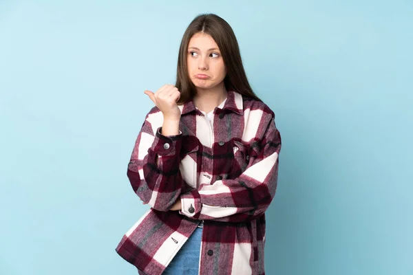 Teenager Caucasian Girl Isolated Blue Background Unhappy Pointing Side — Stock Photo, Image