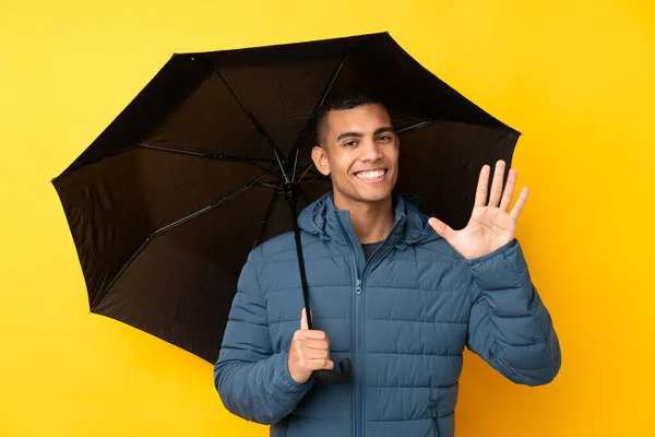 Jovem Homem Bonito Segurando Guarda Chuva Sobre Fundo Amarelo Isolado — Fotografia de Stock