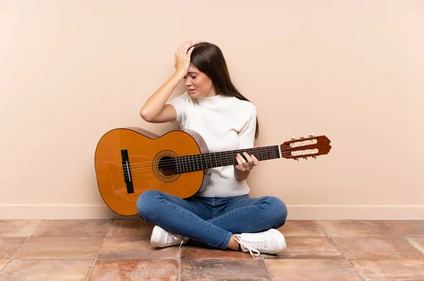 Jovem Com Guitarra Sentada Chão Com Dúvidas Com Expressão Facial — Fotografia de Stock