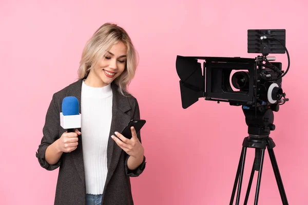 Mulher Repórter Segurando Microfone Reportando Notícias Sobre Fundo Rosa Isolado — Fotografia de Stock