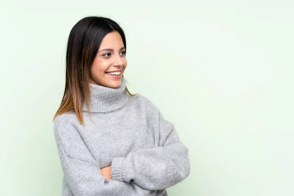 Mujer Vistiendo Suéter Sobre Fondo Verde Aislado Mirando Hacia Lado —  Fotos de Stock