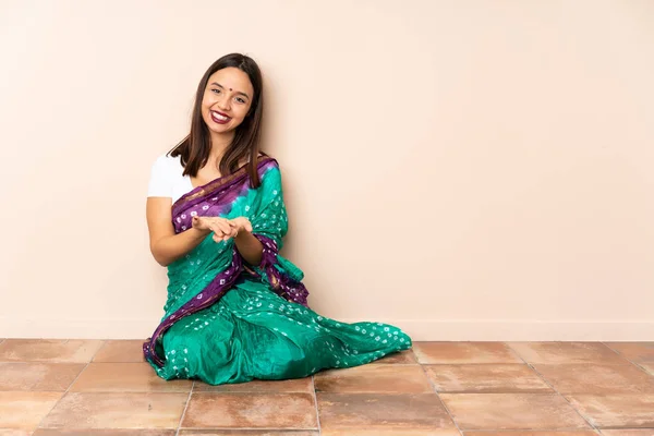 Young Indian Woman Sitting Floor Holding Copyspace Imaginary Palm Insert — Stock Photo, Image