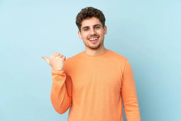 Uomo Caucasico Isolato Sfondo Blu Che Punta Verso Lato Presentare — Foto Stock