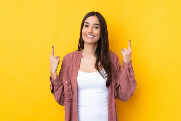 Joven Morena Sobre Aislado Fondo Amarillo Apuntando Una Gran Idea —  Fotos de Stock