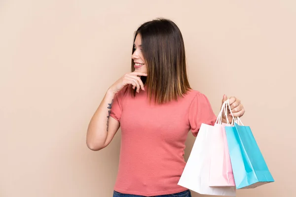 Mujer Joven Con Bolsa Compras Sobre Fondo Aislado Pensando Una — Foto de Stock