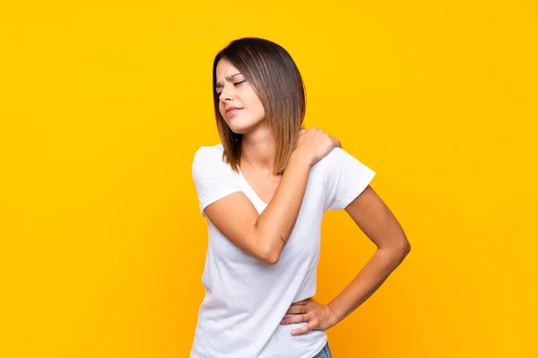 Junge Frau Mit Gelbem Hintergrund Leidet Unter Schulterschmerzen Weil Sie — Stockfoto