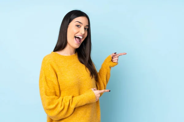 Jovem Mulher Caucasiana Isolado Fundo Azul Surpreendido Apontando Lado — Fotografia de Stock