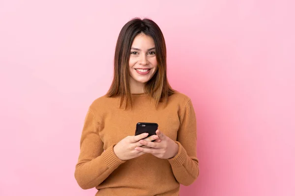 Jonge Vrouw Geïsoleerde Roze Achtergrond Verzenden Van Een Bericht Met — Stockfoto