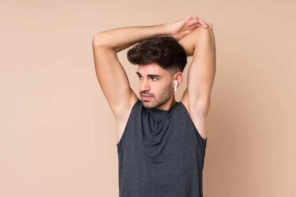 Joven Deportista Sobre Fondo Aislado Brazo Estiramiento —  Fotos de Stock