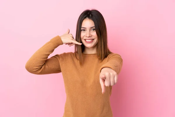 若いです女性以上隔離されたピンクの背景作る電話ジェスチャーと指摘フロント — ストック写真