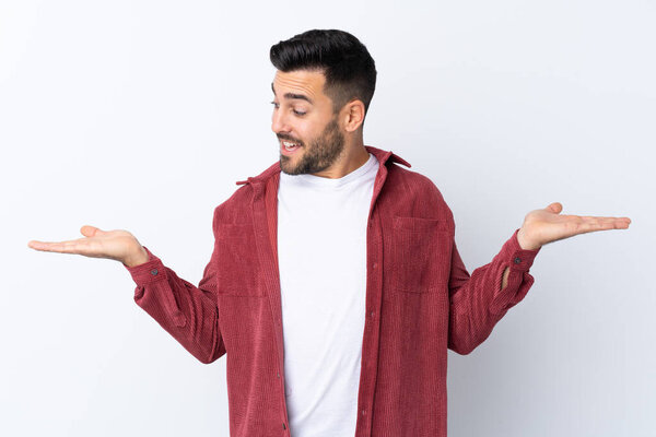 Young handsome man with beard wearing a corduroy jacket over isolated white background holding copyspace with two hands