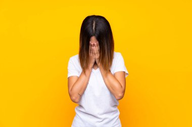 Yorgun ve hasta ifade ile izole sarı arka plan üzerinde genç kadın