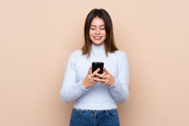 Cep telefonu ile bir mesaj göndererek izole arka plan üzerinde genç kadın