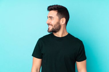 Beyaz tenli yakışıklı adam mavi arka planda izole edilmiş.