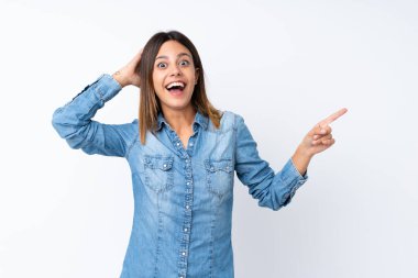 İzole beyaz arka plan üzerinde genç kadın sürpriz ve tarafına parmak işaret