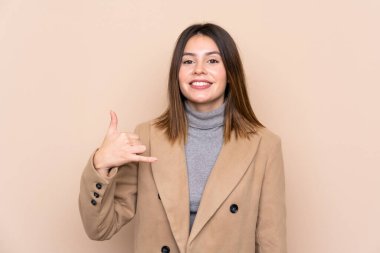 Tecrit edilmiş genç bir kadın telefon jesti yapıyor.