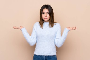 El kaldırırken şüpheleri olan izole arka plan üzerinde genç kadın