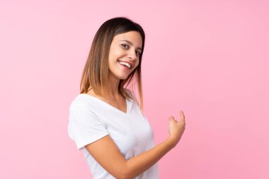 İzole edilmiş pembe arka planı olan genç bir kadın.