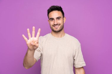 Soyutlanmış mor bir geçmişi olan genç yakışıklı adam mutlu ve parmakları olan dört kişi sayıyor.