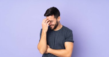 Kafkasyalı yakışıklı adam soyutlanmış mor arka planda gülüyor.