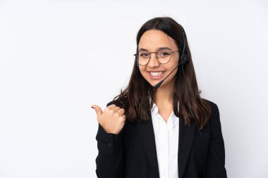 Beyaz arka planda izole edilmiş genç pazarlamacı kadın bir ürünü sunmak için kenarı işaret ediyor.