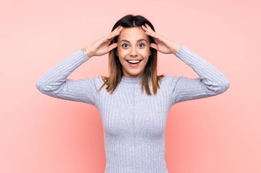 Soyutlanmış pembe arka planlı, sürpriz ifadeli kadın.