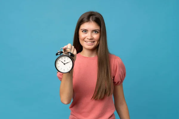 Mujer Joven Sobre Fondo Azul Aislado Sosteniendo Reloj Despertador Vintage — Foto de Stock