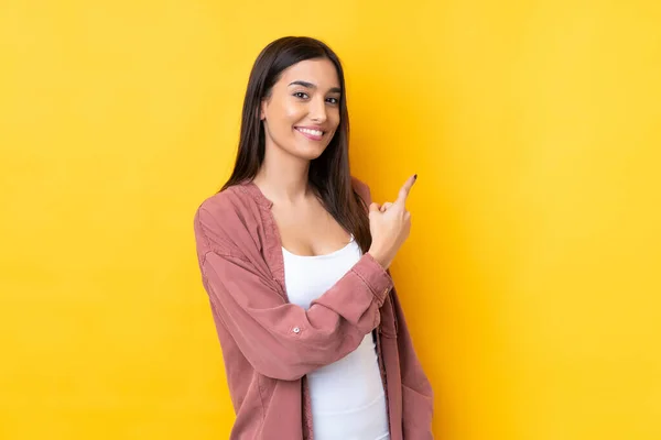 Joven Morena Sobre Fondo Amarillo Aislado Apuntando Hacia Lado Para —  Fotos de Stock