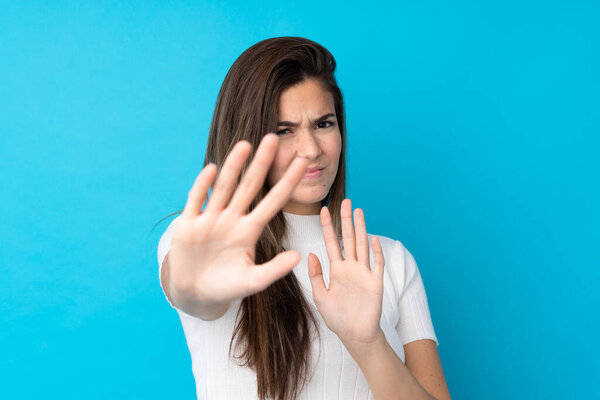 Подросток на изолированном синем фоне нервно протягивая руки к передней