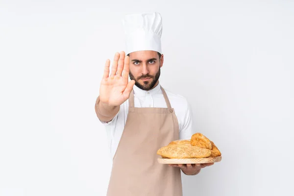 Mannelijke Bakker Houdt Een Tafel Met Verschillende Broden Geïsoleerd Witte — Stockfoto