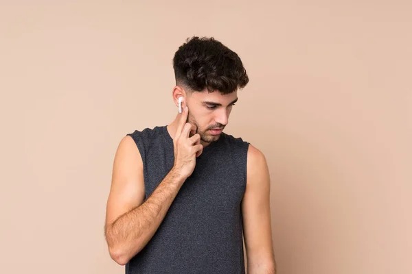 Joven Deportista Sobre Fondo Aislado Escuchando Música —  Fotos de Stock