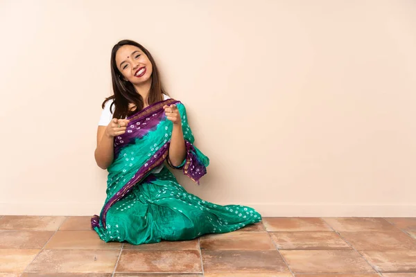 Mujer India Joven Sentada Suelo Apuntando Frente Con Expresión Feliz — Foto de Stock