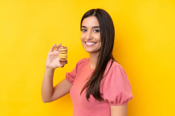 Giovane Donna Bruna Sfondo Giallo Isolato Con Macaron Francesi Colorati — Foto Stock