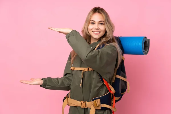 十代のロシアの登山家の女の子とともに大きなバックパックで隔離されたピンクの背景を保持コピースペースに挿入する広告 — ストック写真