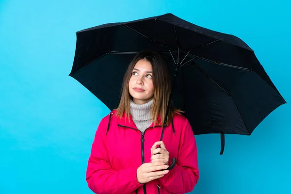 Mujer Joven Sosteniendo Paraguas Sobre Una Pared Azul Aislada Haciendo — Foto de Stock