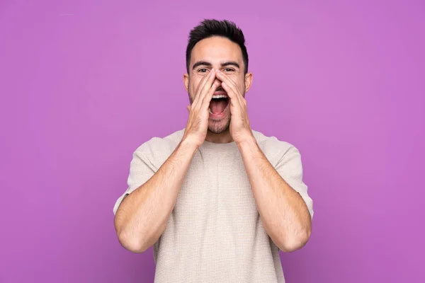 Junger Gutaussehender Mann Vor Isoliertem Lila Hintergrund Schreit Und Kündigt — Stockfoto