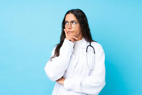 Junge Ärztin Mit Isoliertem Blauem Hintergrund Denkt Sich Eine Idee — Stockfoto