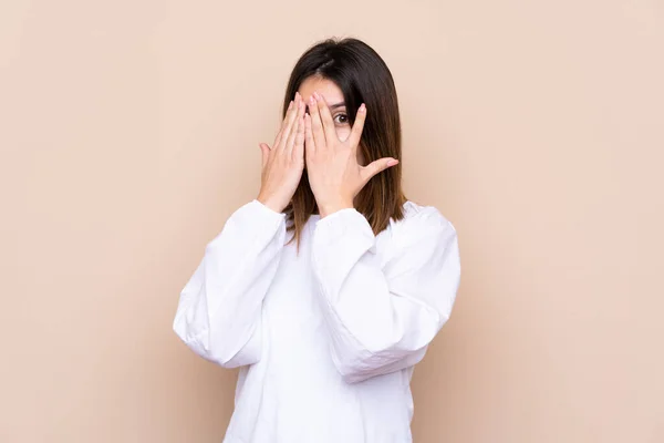 Jovem Mulher Sobre Fundo Isolado Cobrindo Olhos Olhando Através Dos — Fotografia de Stock