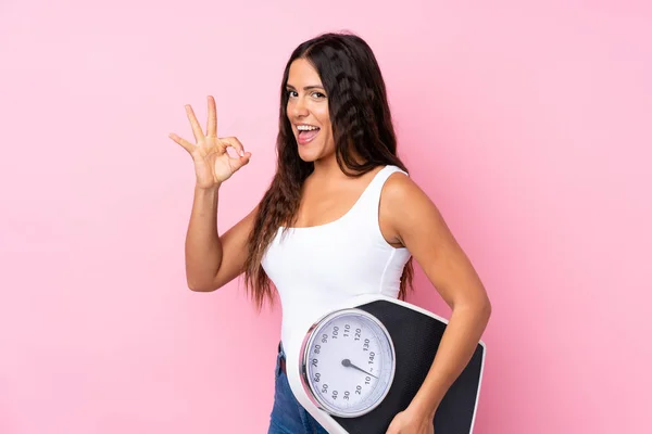 Mujer Joven Sobre Fondo Rosa Aislado Sosteniendo Una Máquina Pesaje — Foto de Stock